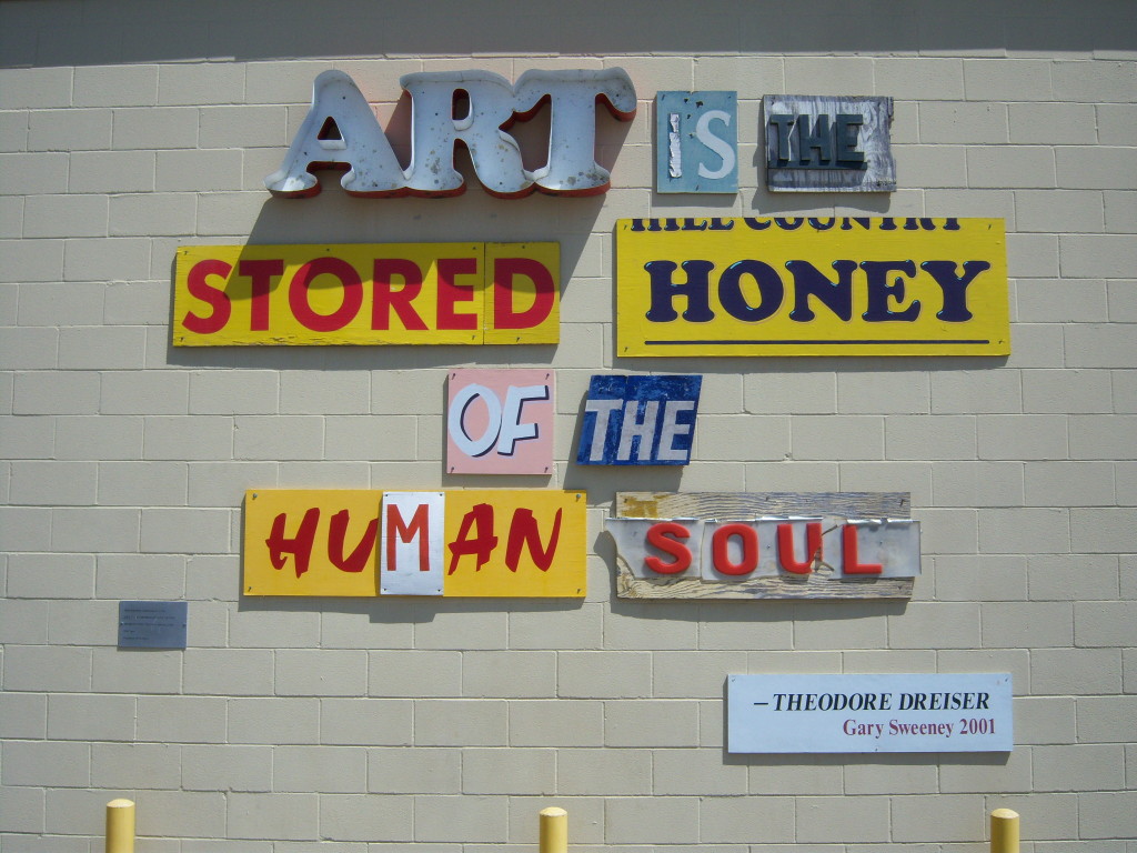 Photo of artwork by Gary Sweeney outside of the San Antonio Museum of Art that reads "Art is the stored honey of the human soul." (Quote by Theodore Dreiser.)