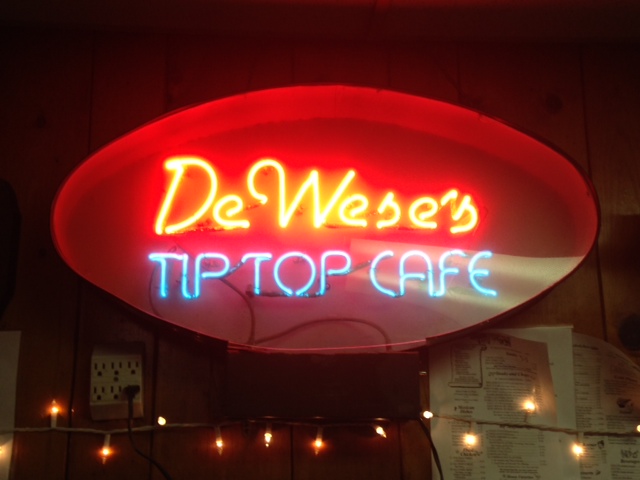 Photo of a neon sign that spells out DeWese's Tip Top Cafe.
