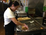 Photo of employee wrapping a dozen tamales at Adelita Tamales & Tortilla Factory.