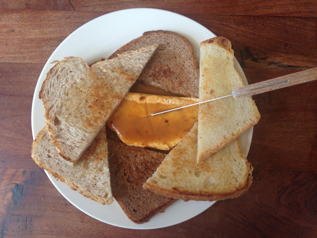 Photo of goat cheese with piloncillo sauce on toasted housemade bread at the Liberty Bar in San Antonio, Texas.