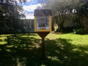 Photo of a bright yellow Little Free Library