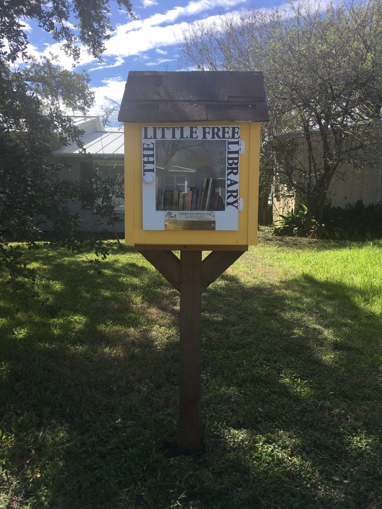 Photo of a Little Free Library painted bright yellow.